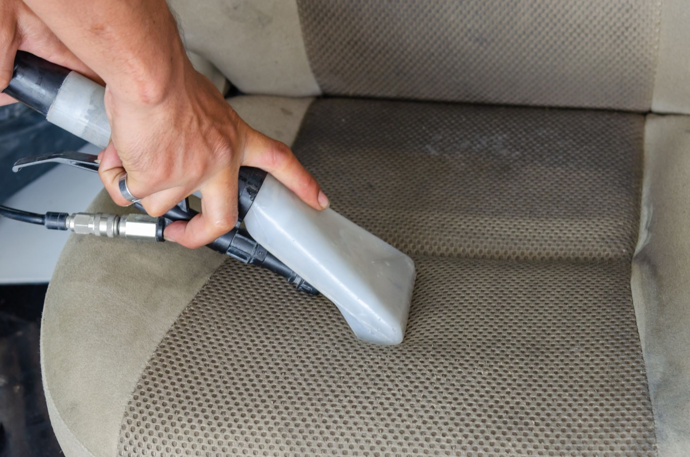 Upholstery extraction tool drawing dirt out of a fabric car seat